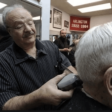 Barber cutting a client's hair in a salon