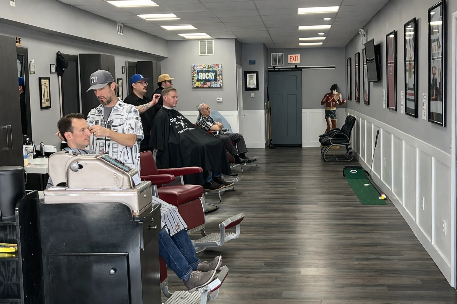Interior of a busy barbershop with clients and stylists